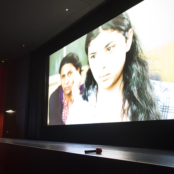 Ein Kinobildschirm auf dem ein Mädchen und eine Frau zu sehen sind.