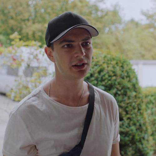 Ein Junge mit einem weißen T-Shirt und einer Cappy.