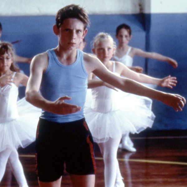 Billy Elliot in the middle of a group of ballet dancers.