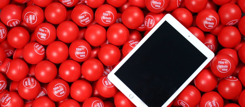 Ein Tablet liegt auf roten Bällen.