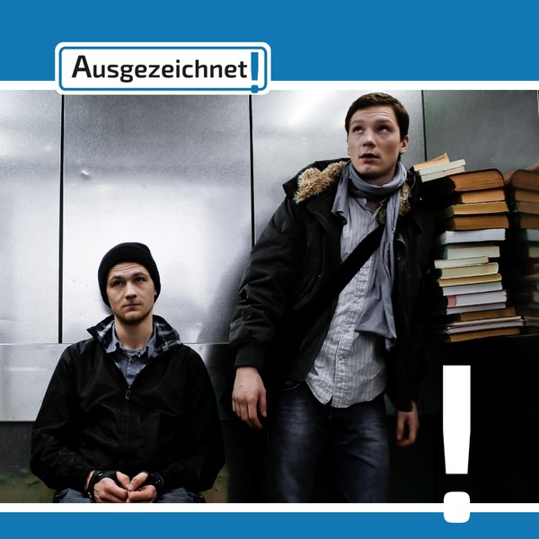 Zwei Männer fahren in einem Aufzug. Der linke sitzt im Rollstuhl, der Rechte transportiert einen Stapel Bücher.