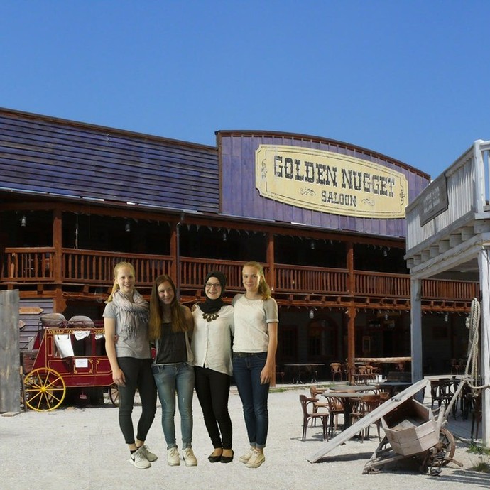 Eine Gruppe Menschen posiert vor einem mit Green Screen eingefügten Hintergrundbild. (vergrößerte Bildansicht wird geöffnet)