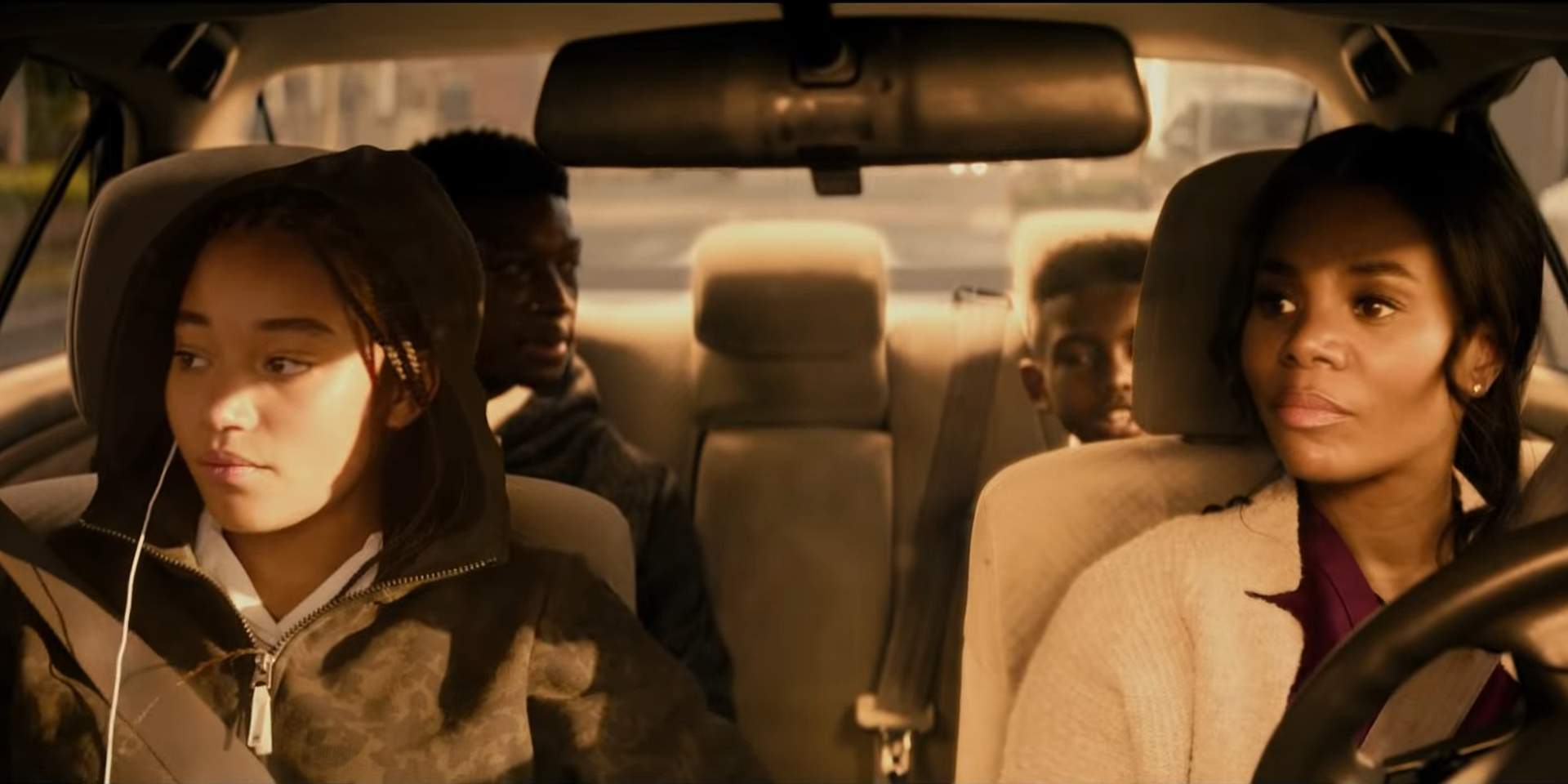 Starr sitzt mit ihrer Familie im Auto. Ihre Mutter sitzt am Steuer, auf der Rückbank ihre beiden Brüder.