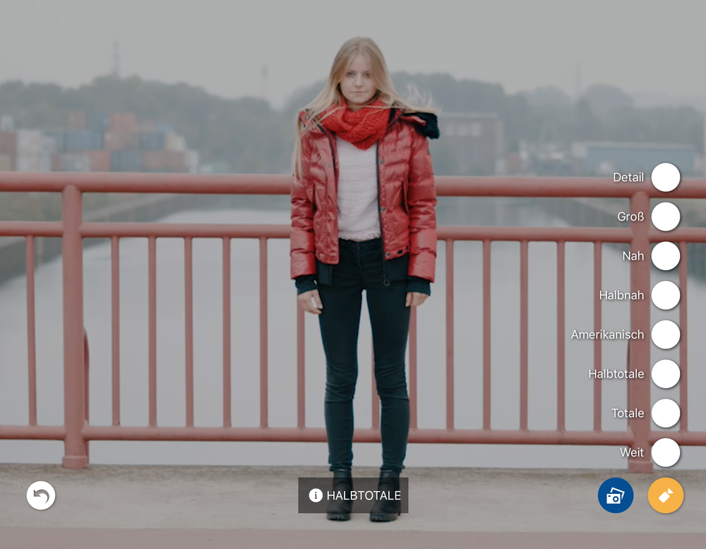 Eine Frau steht auf einer Brücke.