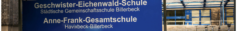 Eine blaues Schild vor einem Gebäude auf dem steht "Geschwister-Eichenwald-Schule und Anne-Frank-Gesamtschule Billerbeck".