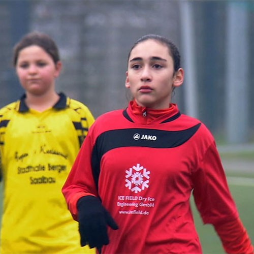 Ein Mädchen mit einer roten Trainingsjacke.