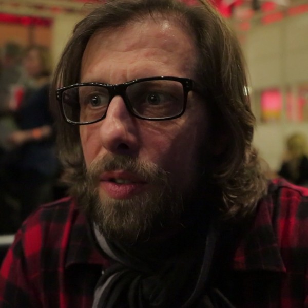 Ein Mann mit braunen Haaren, Bart und Brille.
