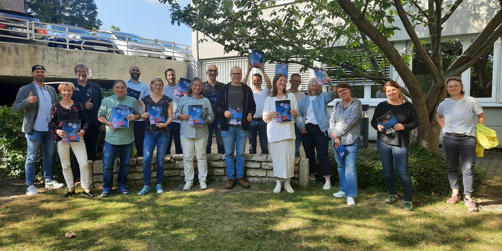 Gruppenfoto der dritten Runde der Basisqualifizierung: Menschen halten Urkunden.