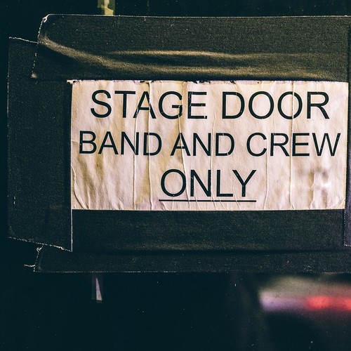 Schild "Stage door band and crwe only" hängt an einer Tür.